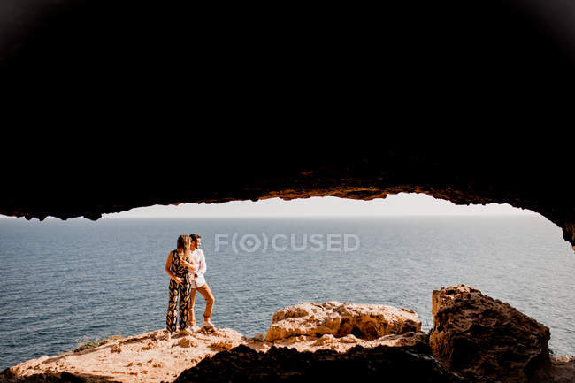 Пара обнимается на скале — стоковое фото