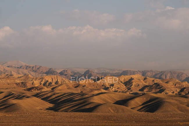 Sandy hills and mountain ridge of Wadi Rum desert against cloudy gray sky in Jordan — Stock Photo