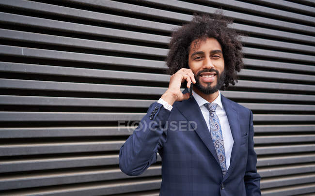 African american man talking by phone near wall — Stock Photo