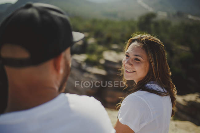 Счастливая пара, сидящая у горной скалы — стоковое фото