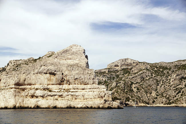 Picturesque view of Calanques Massif with chalk cliffs still water and cloudy sky in France Europe on daytime — Stock Photo