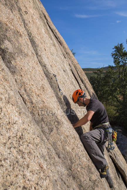 Mann klettert mit Kletterausrüstung auf Felsen in der Natur — Stockfoto