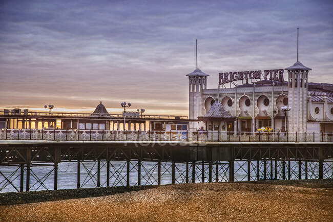 Exterior of beautiful ornamental building located on pier in Brighton against sea and evening sky — Stock Photo
