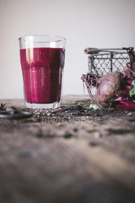Ripe organic delicious beetroot on wooden table with glass of fresh smoothie — Stock Photo