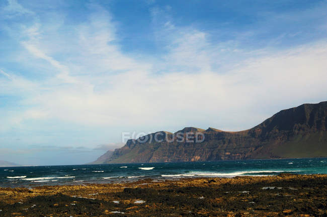 Hermosa y pintoresca vista de la superficie del agua de mar entre altos acantilados rocosos en un día soleado - foto de stock