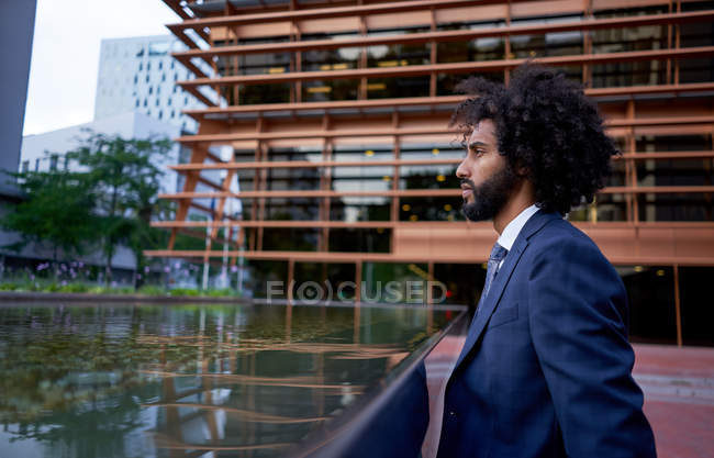 Confiado hombre de negocios afroamericano mirando hacia otro lado - foto de stock