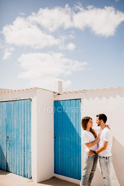 Pareja cariñosa abrazándose cerca de la casa de playa - foto de stock