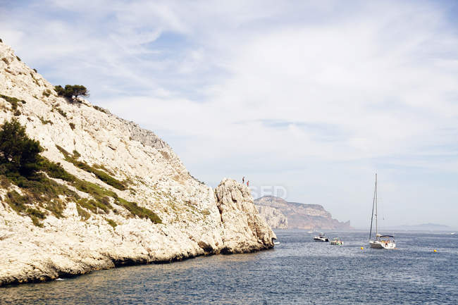 Limestone rocks and boats sailing in sea — Stock Photo