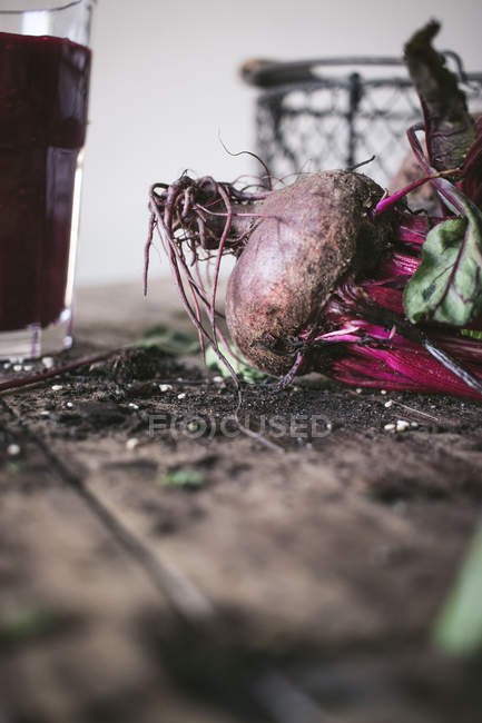 Ripe organic delicious beetroot on wooden table with glass of fresh smoothie — Stock Photo