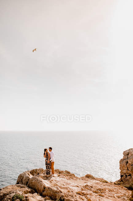 Couple embrassant sur le rocher — Photo de stock