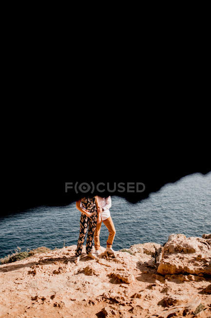 Couple embracing on rock — Stock Photo