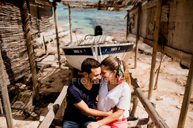 Amante casal abraçando perto de barco arrastado para terra — Fotografia de Stock