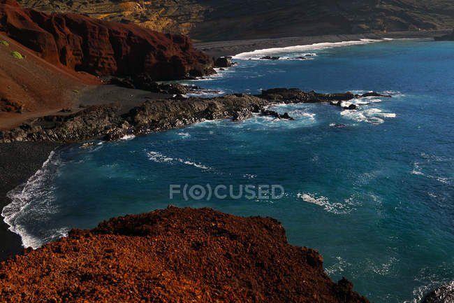 Hermosa y pintoresca vista de la superficie del agua de mar entre altos acantilados rocosos en un día soleado - foto de stock