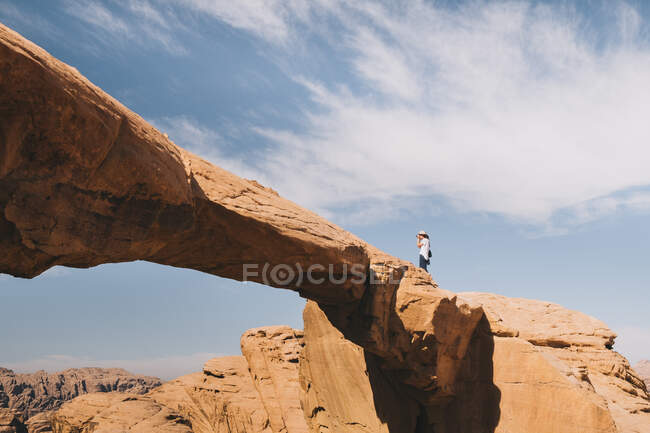 Анонимный фотограф на скале в пустыне — стоковое фото