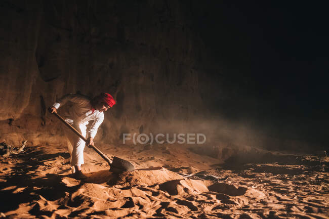 Arab men digging sand near cliff — Stock Photo