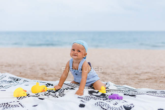 Ritratto di bambino che gioca con le anatre di gomma sulla spiaggia — Foto stock