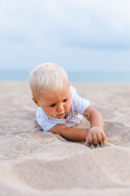 Frontal view of a blonde baby on the beach — Stock Photo