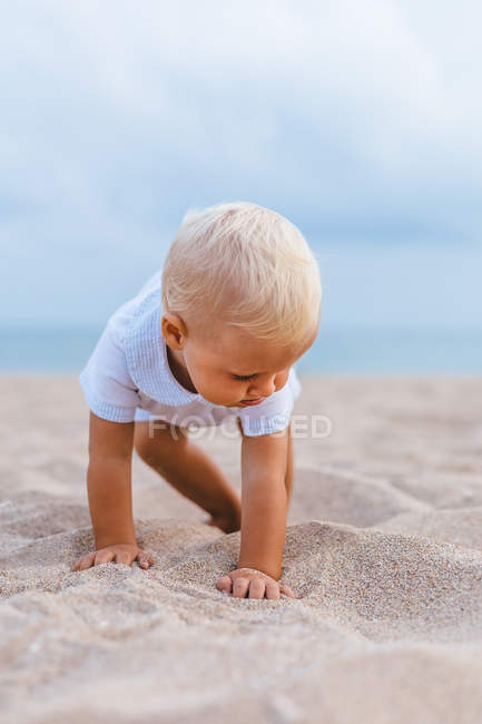 Frontal view of a blonde baby on the beach — Stock Photo