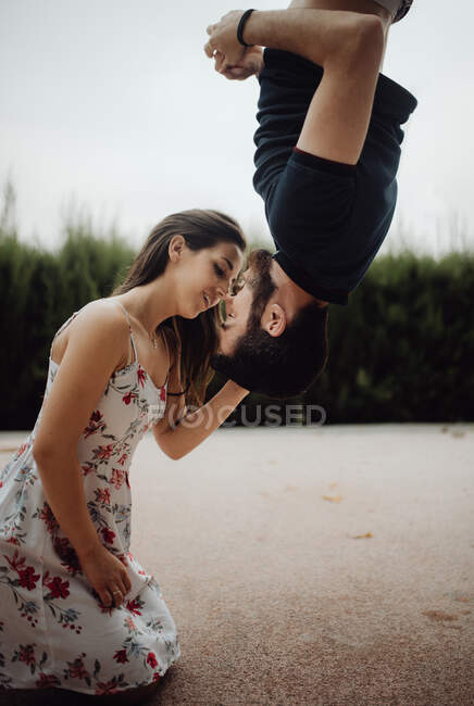 Tender couple kissing upside down on rural street — Stock Photo