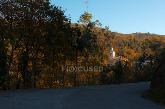 Road near church and autumn trees — Stock Photo