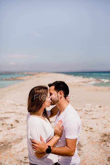 Casal amoroso abraçando na costa — Fotografia de Stock