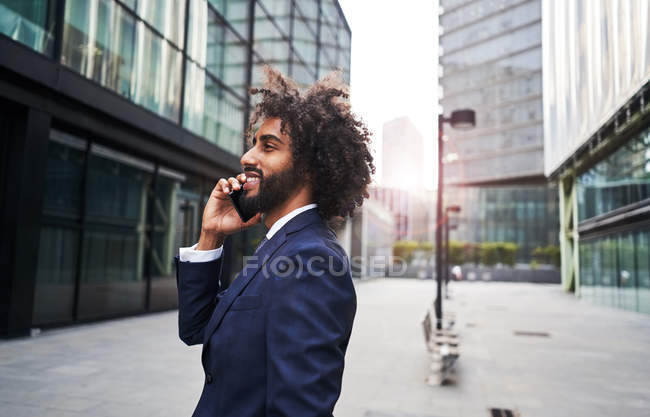 Rizado africano americano hombre sonriendo en la calle - foto de stock
