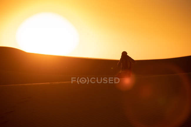 Unerkennbare Silhouette eines Reisenden, der Dünen fotografiert, während er auf Sand in der erstaunlichen Wüste steht — Stockfoto