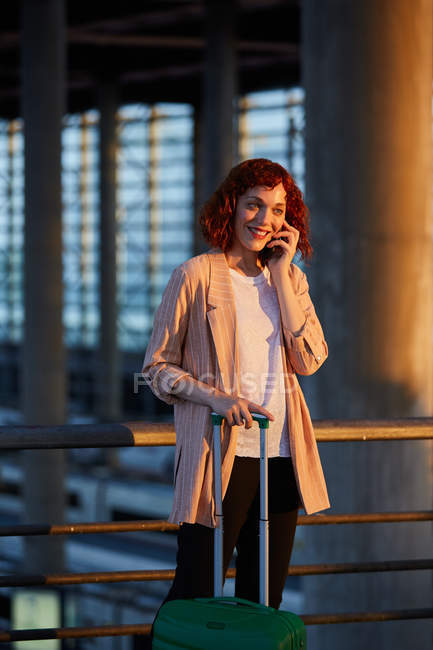 Sorrindo jovem mulher falando ao telefone na estação — Fotografia de Stock