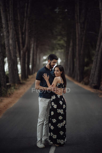 Amante casal abraçando no caminho na floresta nebulosa — Fotografia de Stock