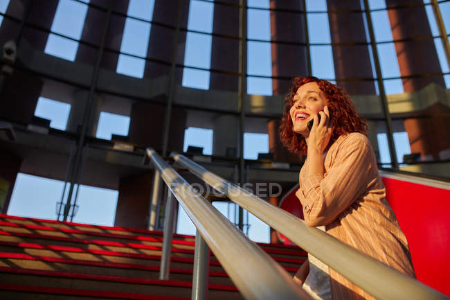 Beautiful young female communicating via smartphone at station — Stock Photo