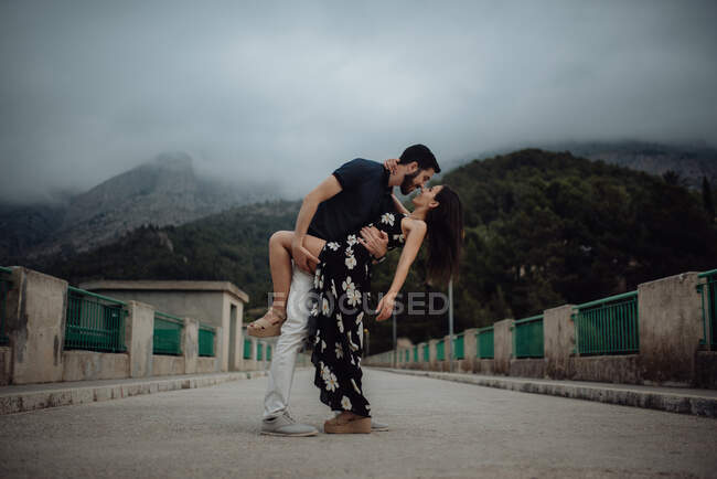 Sinnliches Paar umarmt sich auf ländlicher Brücke — Stockfoto