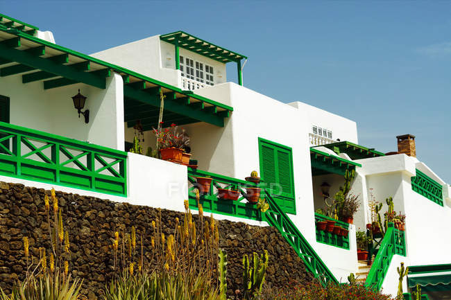 Extérieur d'une maison confortable avec mur blanc et clôture verte et terrasse ouverte à Lanzarote, Iles Canaries, Espagne — Photo de stock