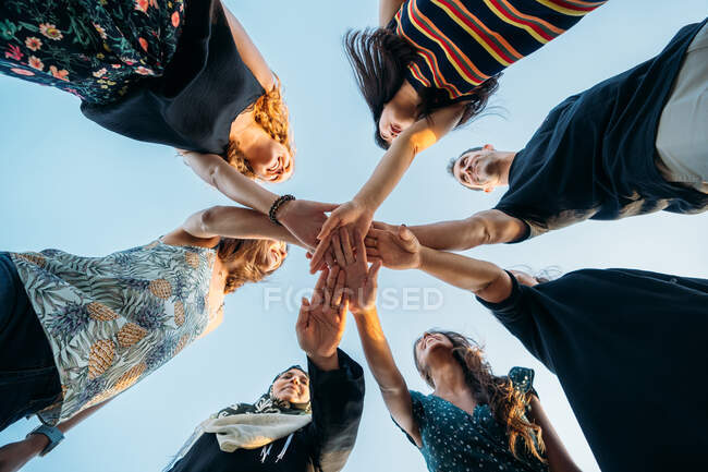 Um grupo de amigos unindo as mãos fazendo uma promessa na praia — Fotografia de Stock