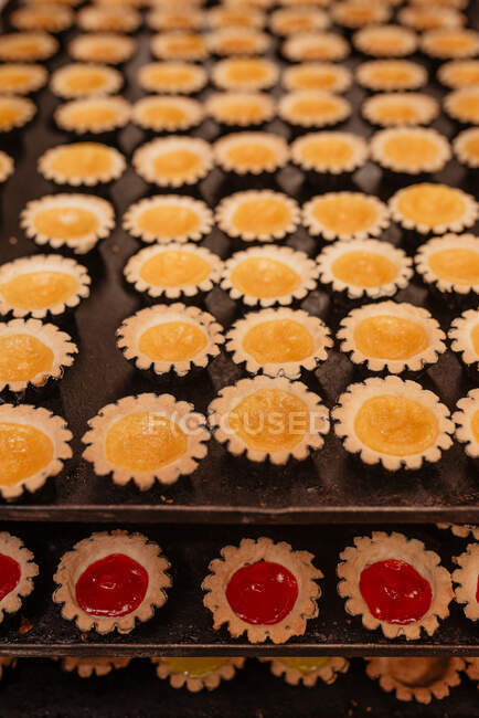 Сверху маленькие кондитерские ящики, наполненные сладким фруктовым желе и помещенные на металлические подносы в пекарне — стоковое фото