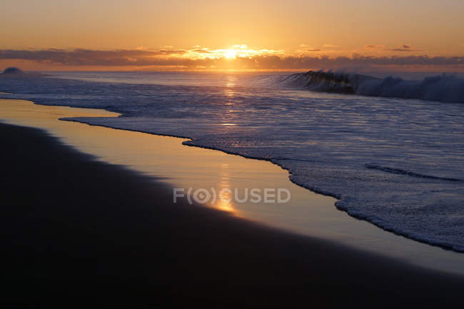 Buenas puestas de sol sobre la tranquila costa - foto de stock
