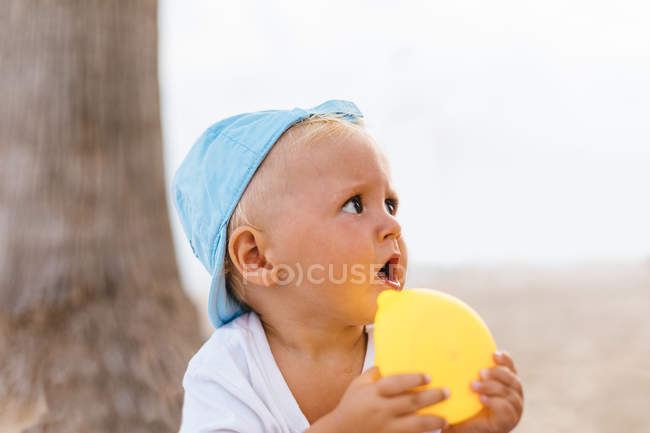 Ritratto di bambino che gioca con le anatre di gomma sulla spiaggia — Foto stock