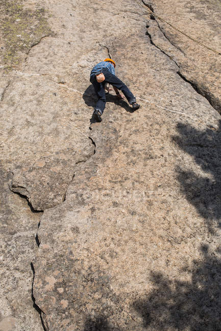 Desde abajo de escalador libre escalando en la naturaleza - foto de stock