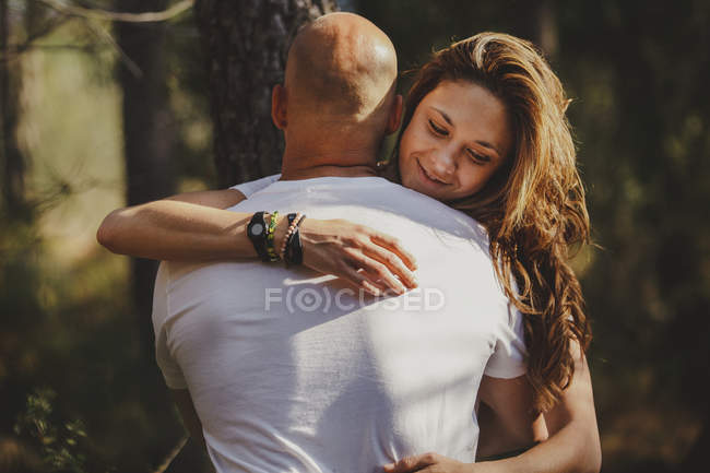 Feliz pareja abrazada en los bosques - foto de stock