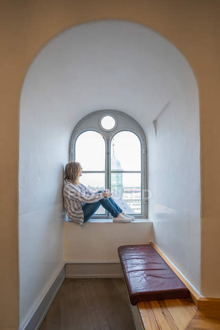 Entspannte Frau ruht auf Fensterbank — Stockfoto
