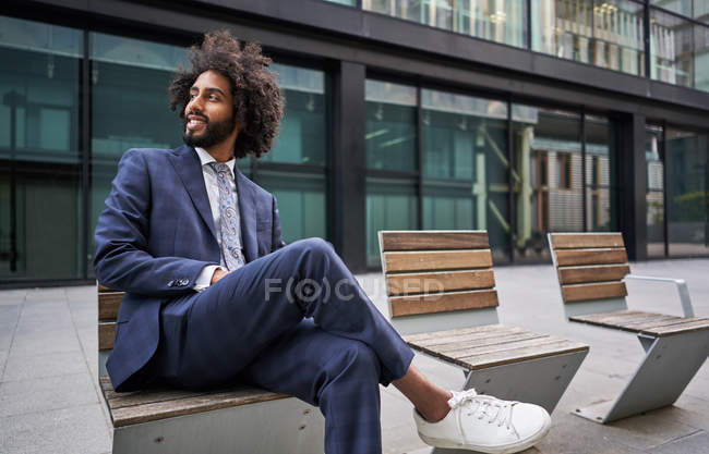 Heureux entrepreneur afro-américain souriant assis à l'extérieur — Photo de stock