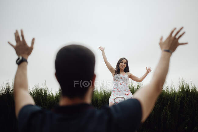 Радостная пара на детской площадке против травянистого поля — стоковое фото