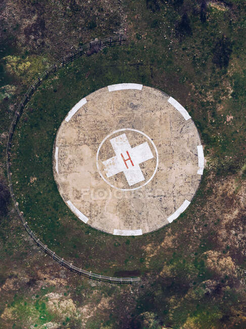 Drone top view of round concrete helipad on grassy rural valley on summer day — Stock Photo