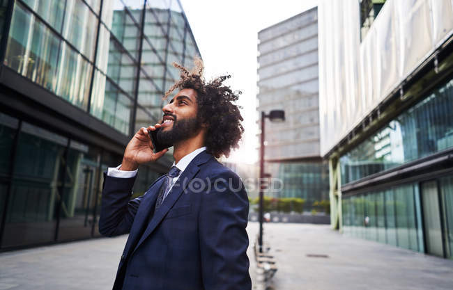 Кудрявый африканский американец улыбается на улице — стоковое фото
