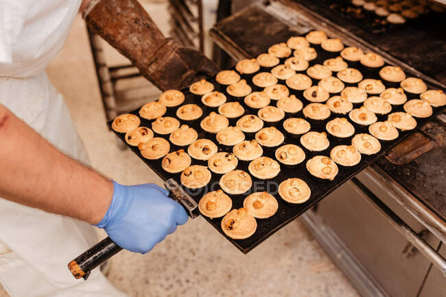 Crop man заглядає всередину професійної печі під час роботи в хлібопекарні — стокове фото