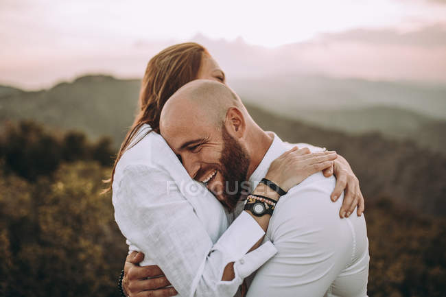 Un couple affectueux s'amuse dans une vallée vallonnée — Photo de stock