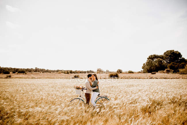 Amantes sinceros posando de bicicleta no campo de centeio — Fotografia de Stock