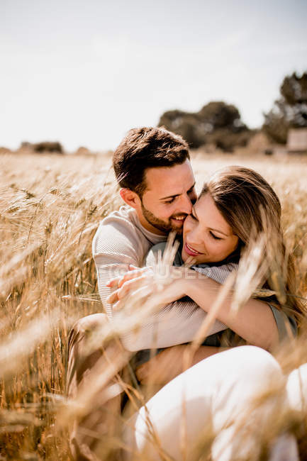 Закохані обіймаються на пшеничному полі — стокове фото