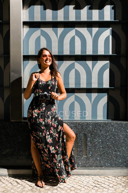 Mulher linda pacífica na roupa da moda e óculos de sol brilhantes em pé ao lado de azulejos parede exótica na rua cênica — Fotografia de Stock