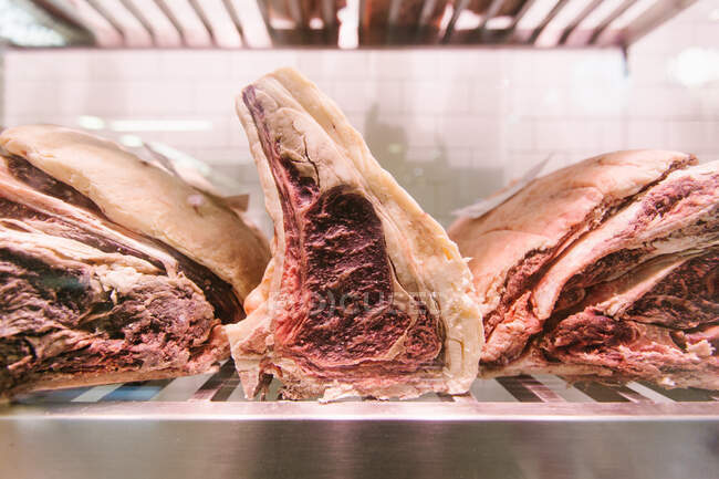 Bistecca di manzo cruda su un refrigeratore in una macelleria per la stagionatura — Foto stock
