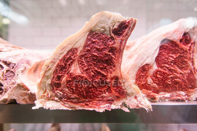 Raw beef steak on a chiller at a butcher's shop for maturing — Stock Photo